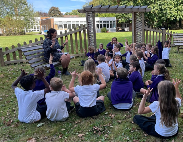 Students with a teacher on a grassy area