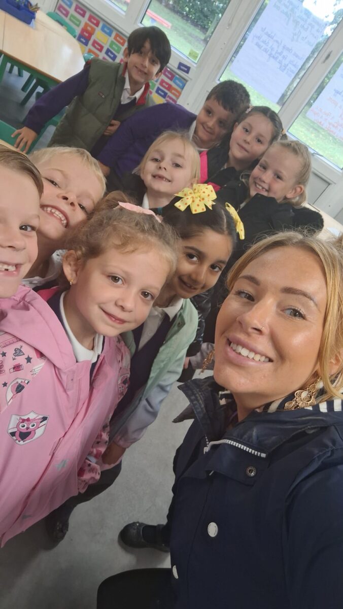 A teacher taking a selfie with several students