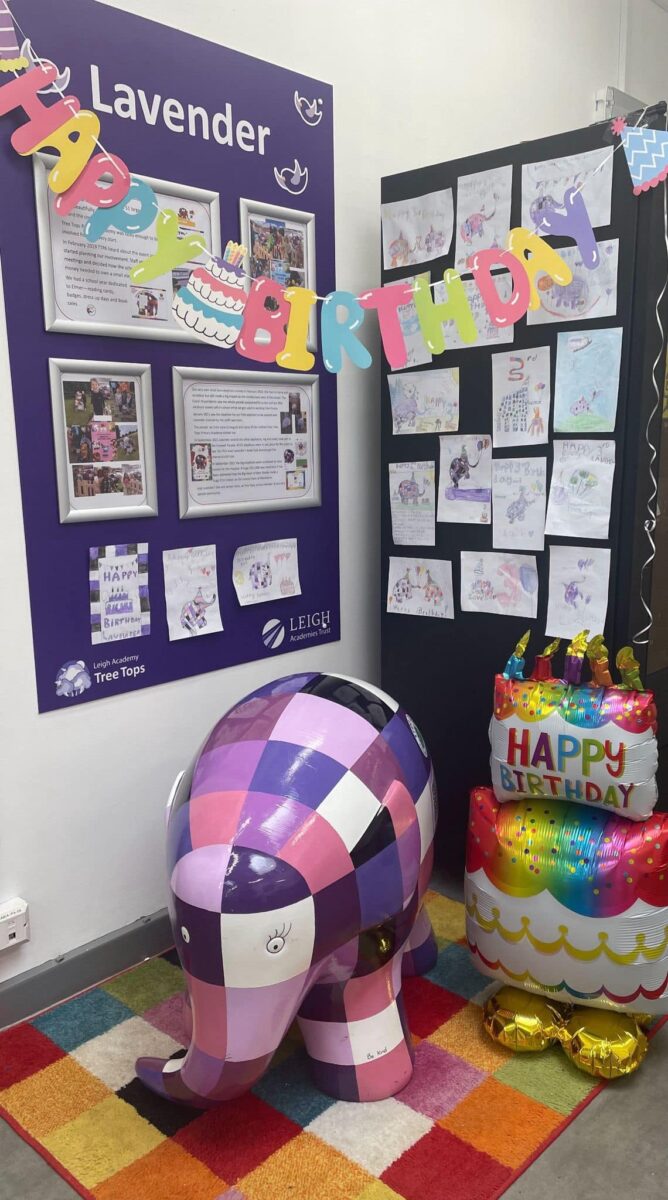 Lavender the elephant under a happy birthday banner