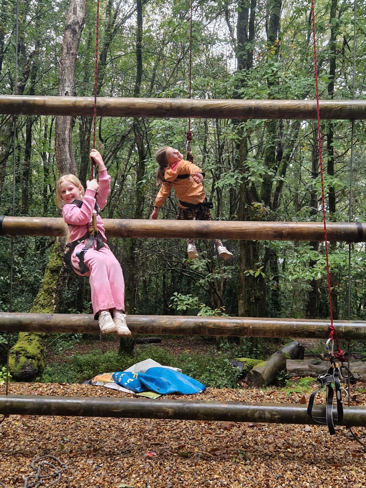 2 students hanging from harnesses, smiling