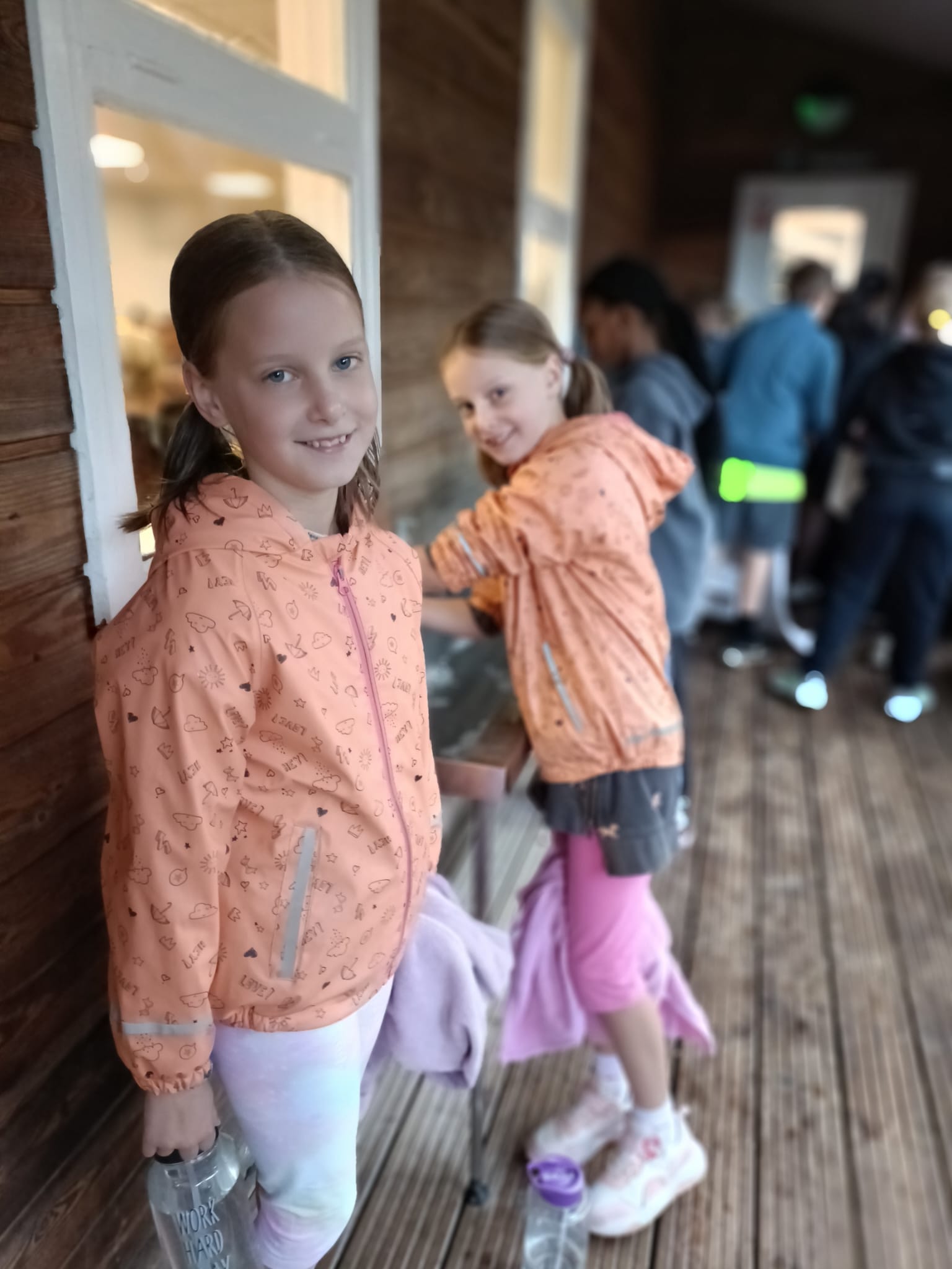 2 students outside a lodge, smiling