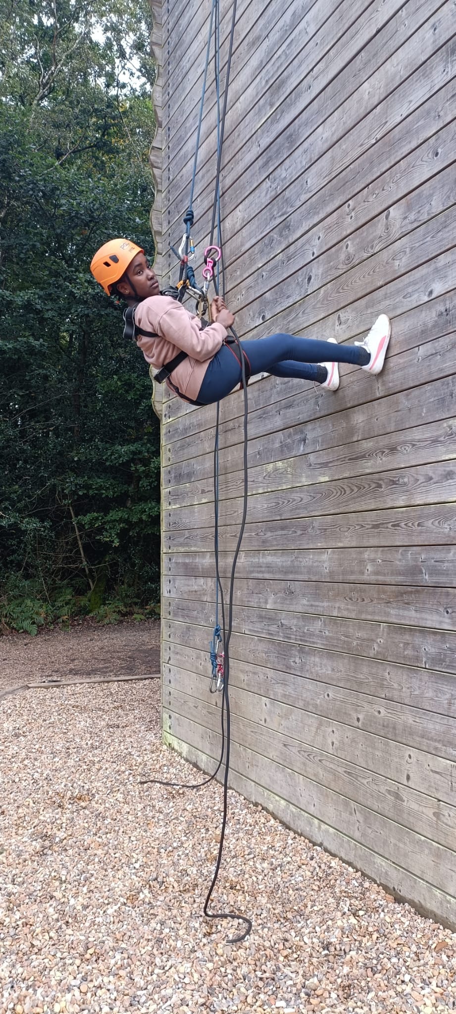 A child abseiling down a wall