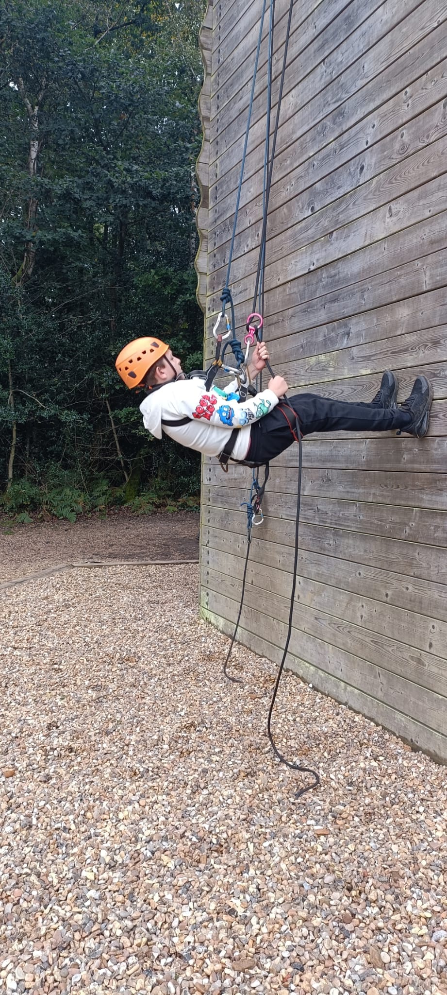 A child abseiling down a wall