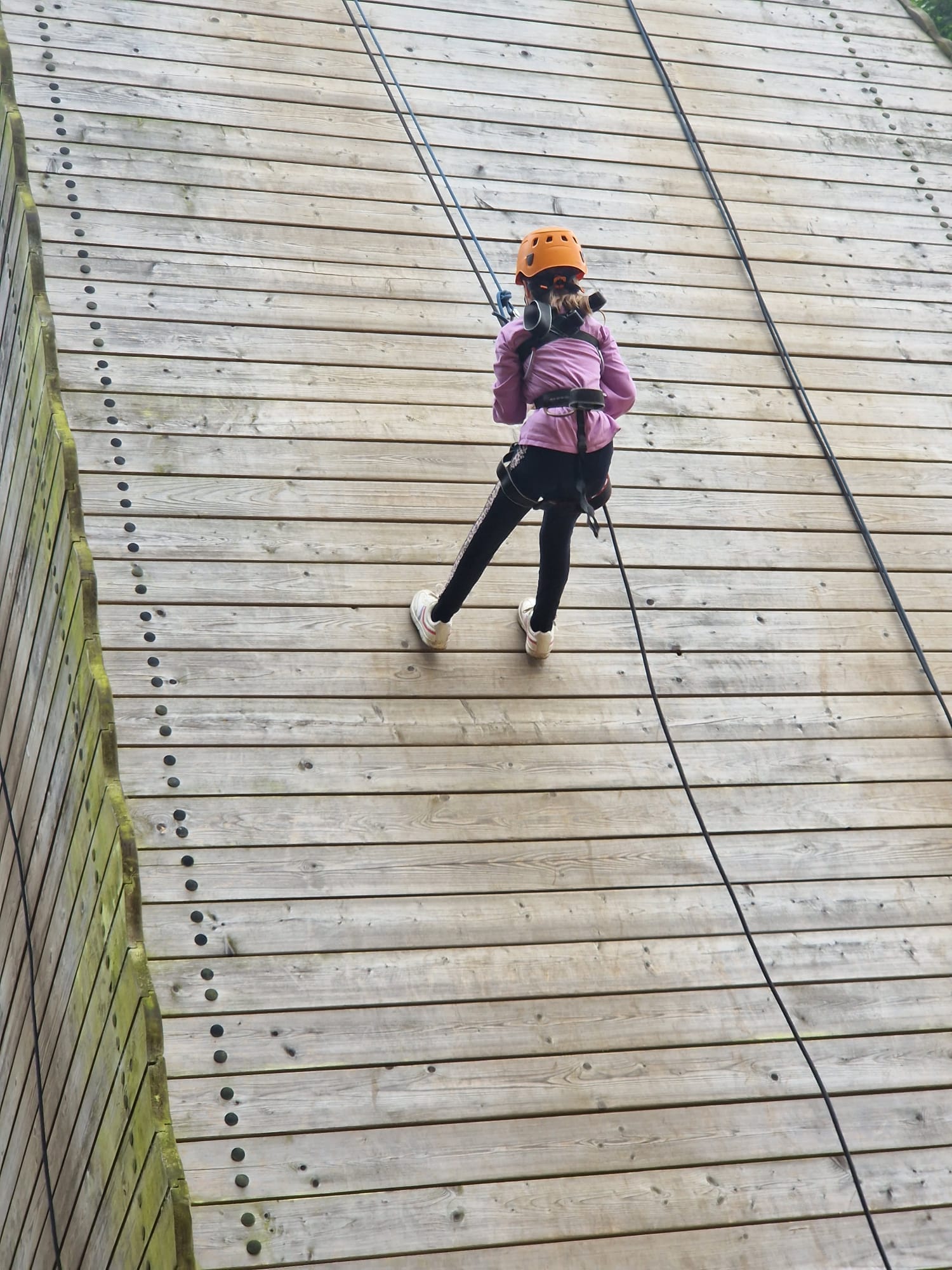 A child abseiling down a wall
