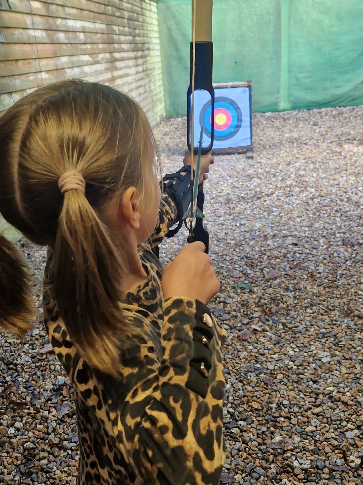 A student shooting a bow and arrow