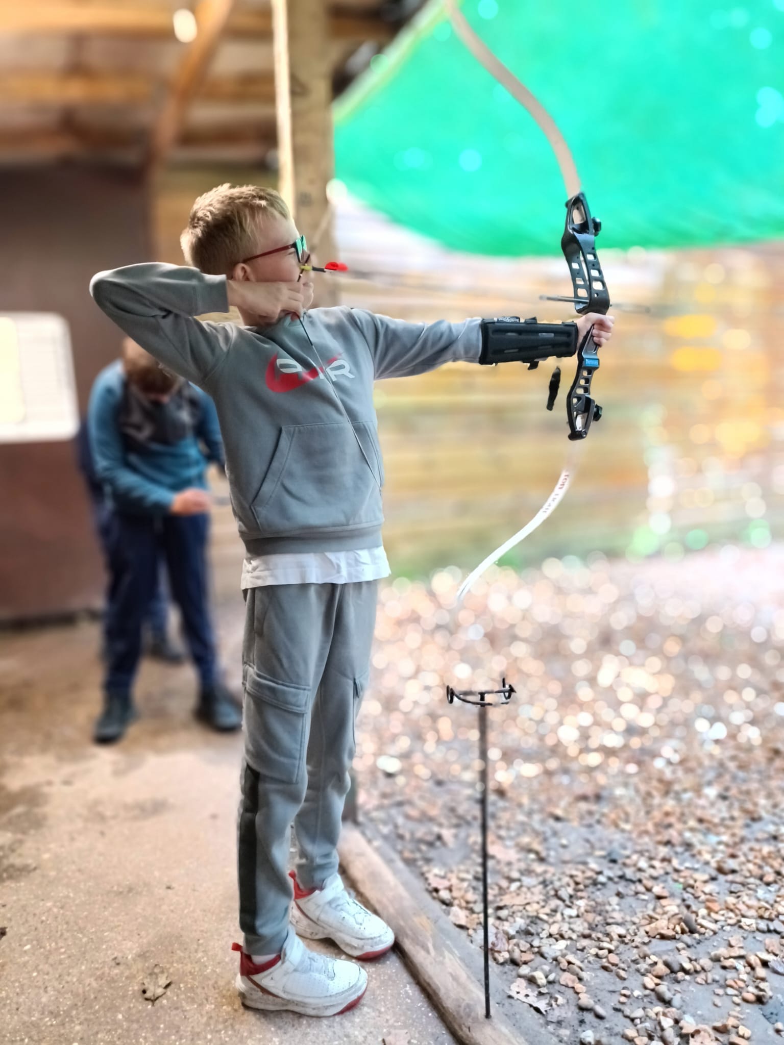 A student shooting a bow and arrow