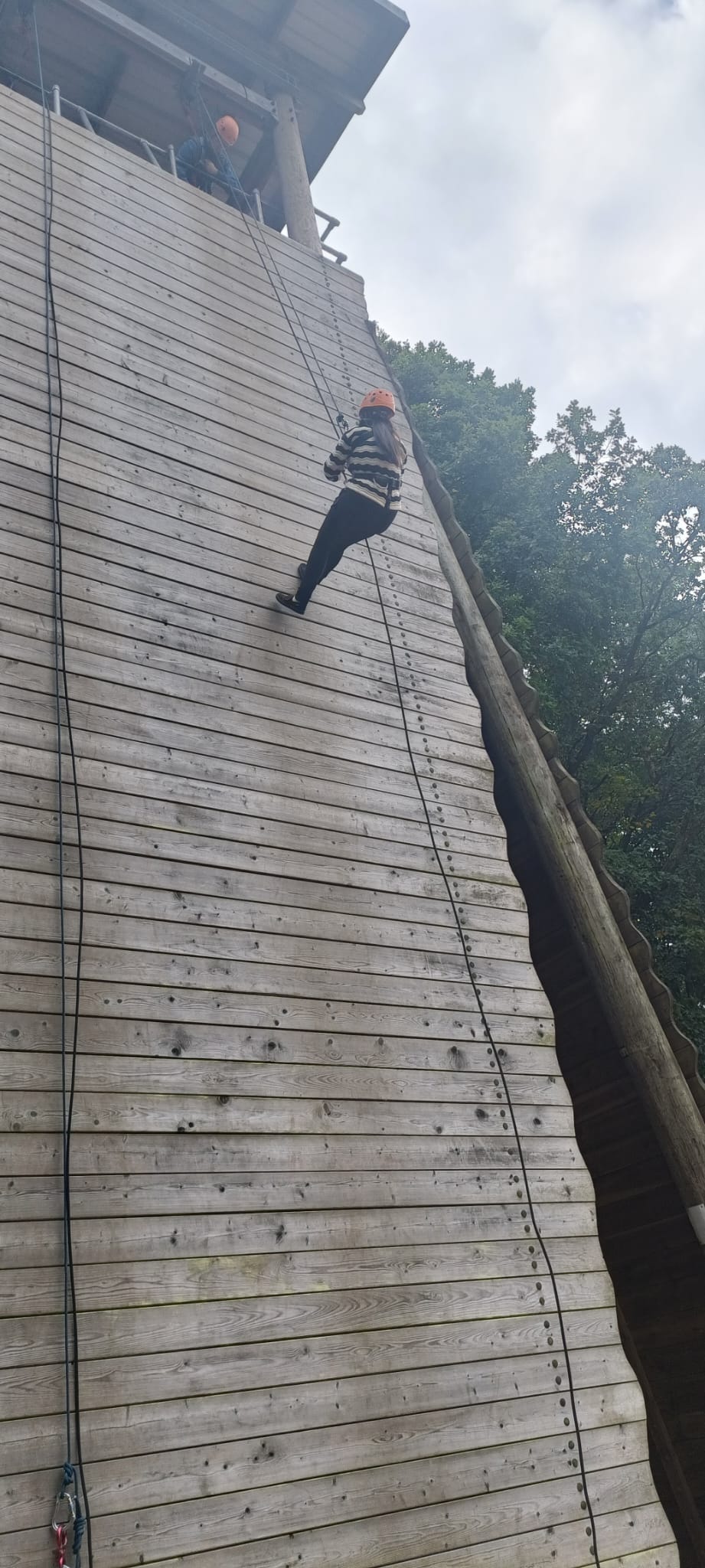 A child abseiling down a wall