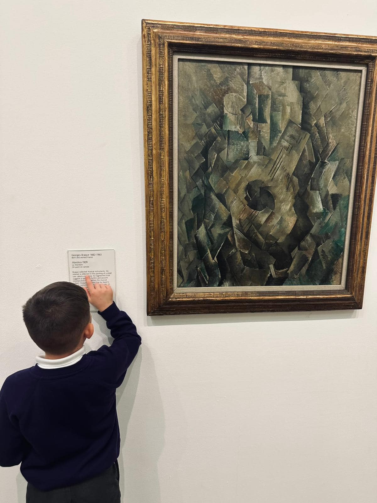 A student reading the information next to a piece of artwork